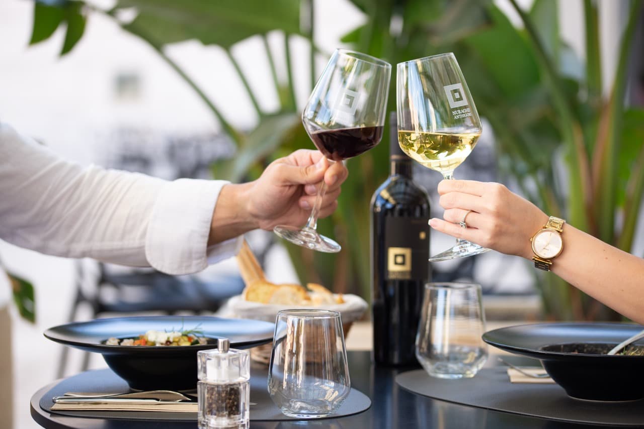 Due clienti brindano con calici di vino al tavolo di un ristorante